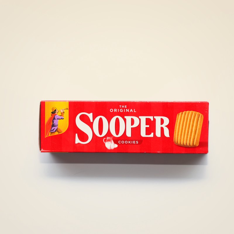 A red box of Sooper cookies against a warm cream background.